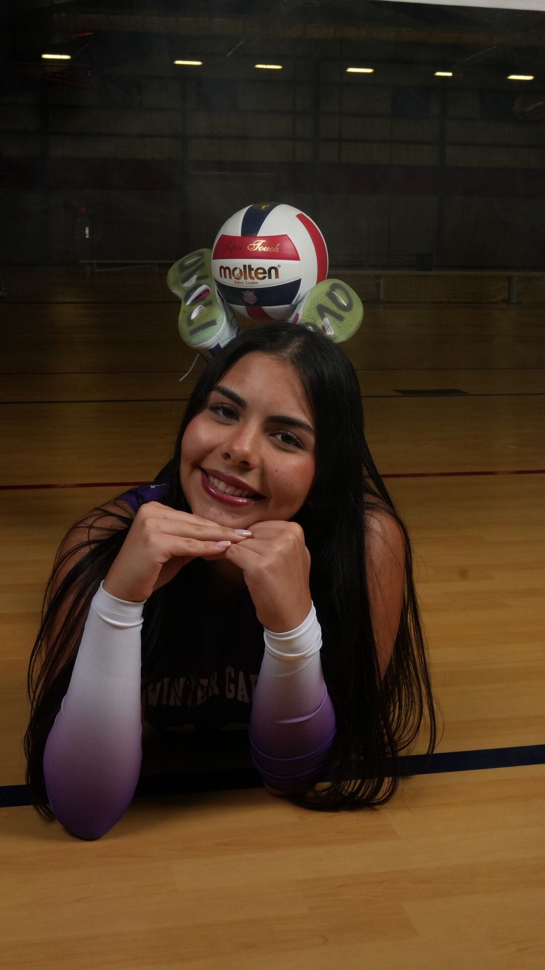 Player lying on the court with the ball on her head
